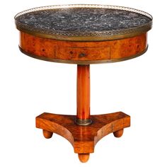 a wooden table with marble top and metal trimmings on the bottom, against a white background