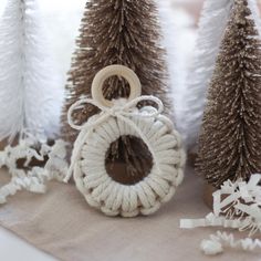 some white and brown decorations are on a table with pine trees in the back ground