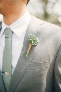 a man wearing a suit and tie with a boutonniere on his lapel