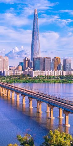 a large bridge crossing across a river with tall buildings in the background