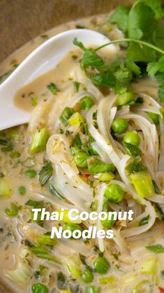 thai coconut noodle soup in a bowl with a spoon and garnishes