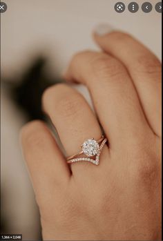 a woman's hand with a diamond ring on top of her finger and an engagement band