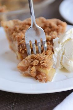 a piece of pie and ice cream on a white plate with a fork in it