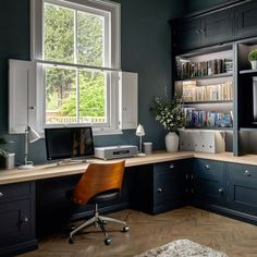 a home office with black walls and wooden floors