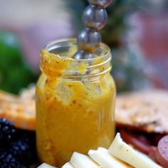 a jar filled with fruit and cheese on top of a table