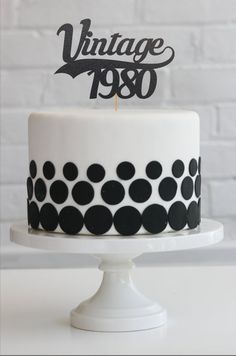 a white cake with black polka dots on it and the words vintage 799 written on top