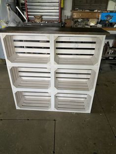 a white cabinet with shutters on top in a garage