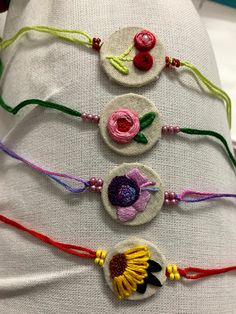 three bracelets with flowers and beads on them