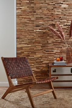 a wooden chair sitting on top of a rug next to a vase filled with flowers