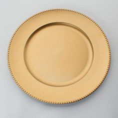 an empty plate with beaded edges on a white surface