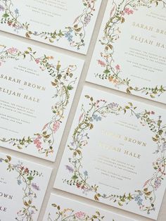 the wedding stationery is laid out on top of each other, with floral designs