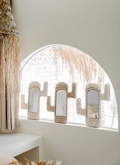 three decorative mirrors are hanging in front of a window