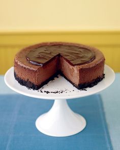 a chocolate cheesecake on a white cake plate