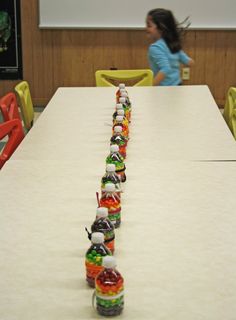 there is a long table with many bottles on it and two children in the background