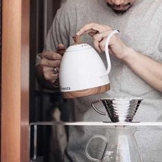 a man pours coffee into a glass pitcher