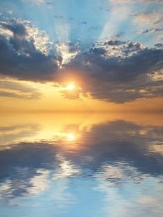 the sun is setting over the ocean with clouds in the sky and water reflecting on the surface