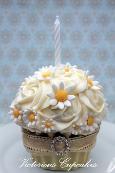 a cupcake decorated with white and yellow flowers