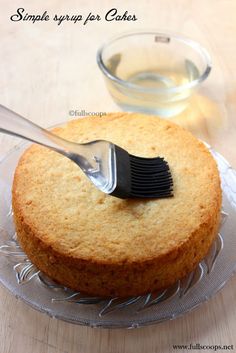 a cake sitting on top of a glass plate with a plastic fork sticking out of it