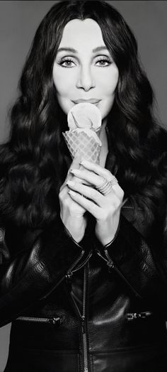 a black and white photo of a woman holding an ice cream cone in her hands