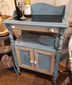 an old blue painted cabinet with wine bottles on top