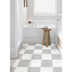 a white and grey bathroom with checkered tile flooring on the walls, counter tops and stools