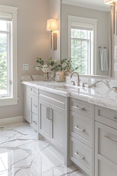 a large bathroom with two sinks and marble counter tops in front of three windows on either side of the sink