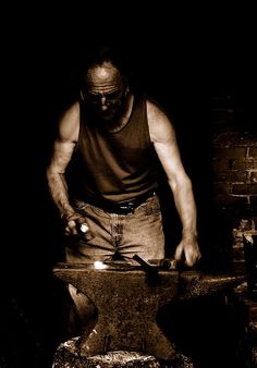 a man is working on an old fire hydrant in the dark with his hands