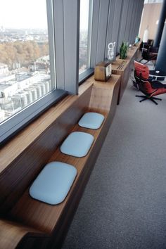 three blue stools sit on the edge of a window sill in an office