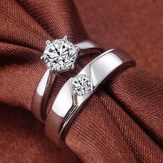 two white gold wedding rings on top of each other, with one diamond in the middle