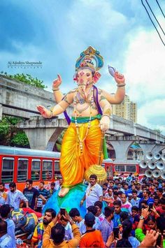 a large statue of the god ganesh in front of a crowd