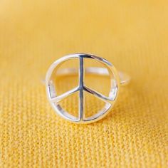 Add joy and good vibes to any outfit with our Peace Sign Ring. This simple silver piece features a delicate band, with a cutout peace sign design that spreads love (and ‘70s style). Details: Brass base with silver plated E-coating Peace sign is approximately 13mm diameter Because jewelry products are handcrafted by artisans, dimensions may vary from piece to piece Peace Sign Design, Peace Sign Ring, Beachy Jewelry, Pura Vida Bracelets, Pinky Promise, 70s Style, Spread Love, Silver Pieces, Peace Sign