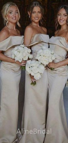 three bridesmaids pose for a photo in their dresses and bouquets at the wedding