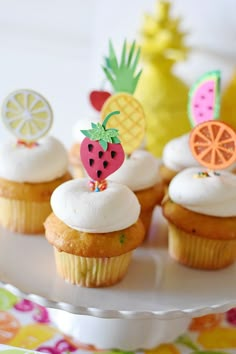 cupcakes decorated with fruit and decorations on a plate