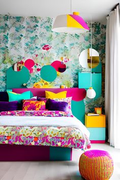 a bedroom with colorful bedding and pillows