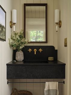 a bathroom sink sitting under a mirror next to a basket