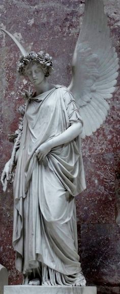 an angel statue in front of a wall