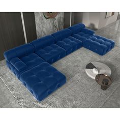 a blue sectional sofa sitting on top of a rug next to a table and chair