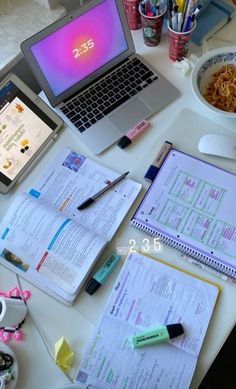 an open laptop computer sitting on top of a desk next to a bowl of food