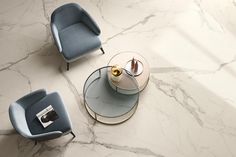 two chairs and a table on a marble floor