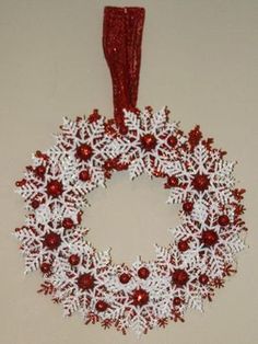 a red and white snowflake wreath hanging on a wall