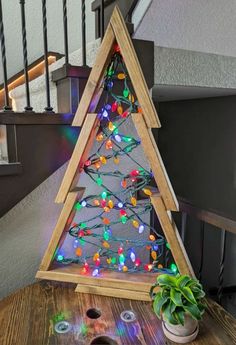 a wooden christmas tree with lights on it