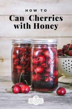 two jars filled with cherries sitting on top of a table