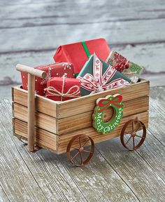 a wooden wagon filled with presents on top of a wooden table