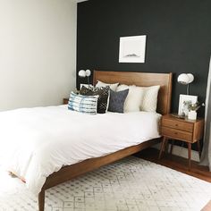 a bed with white sheets and pillows in a room