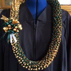 a green and gold necklace on a mannequin's dummy wearing a black shirt