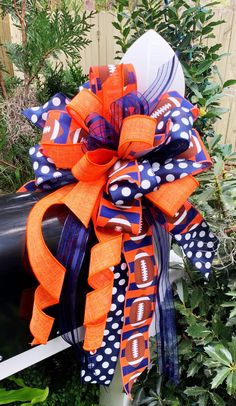 an orange and blue bow with footballs on it