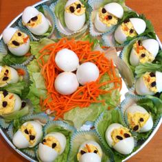 an assortment of eggs and carrots in cups on a plate with lettuce