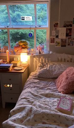 a bedroom with a bed, desk and window in the corner that has pictures on it