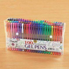 a pack of colorful gel pens sitting on top of a wooden table