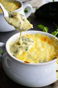 a spoon full of cheese being lifted from a bowl